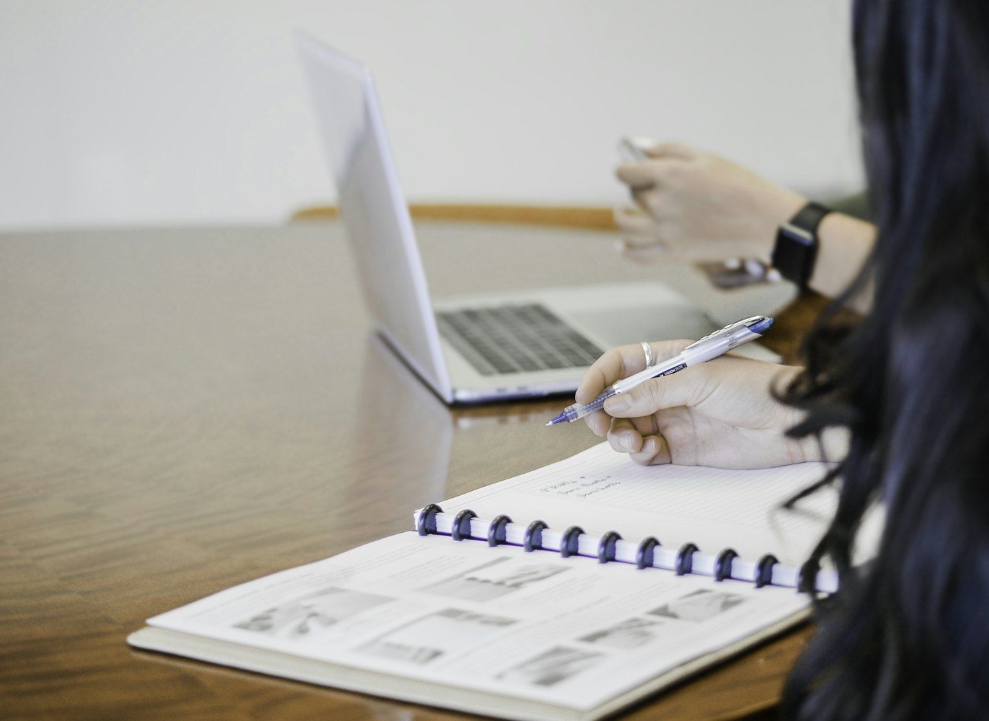 Person writing notes at table