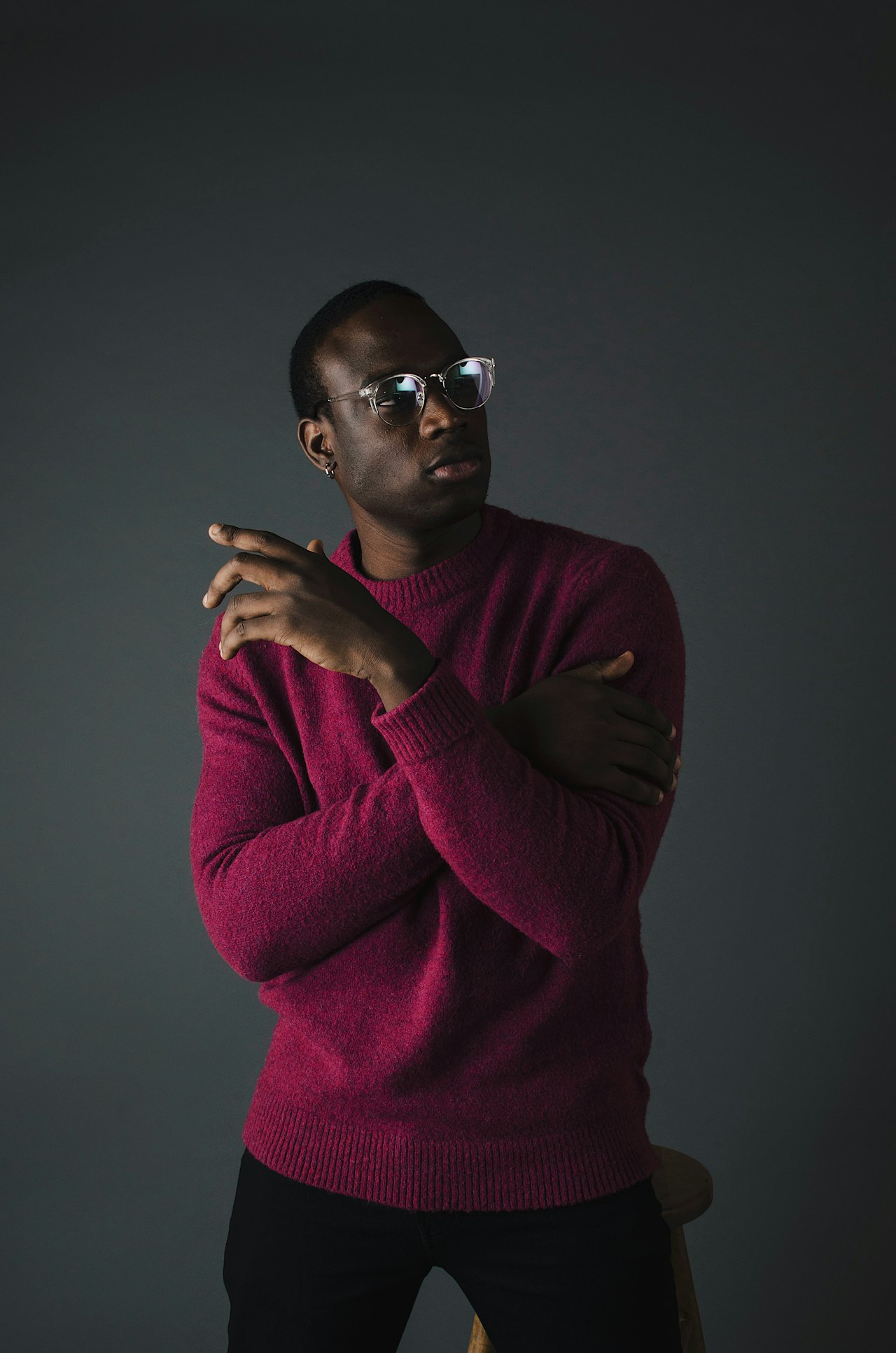 Person in red sweater, thoughtful pose.