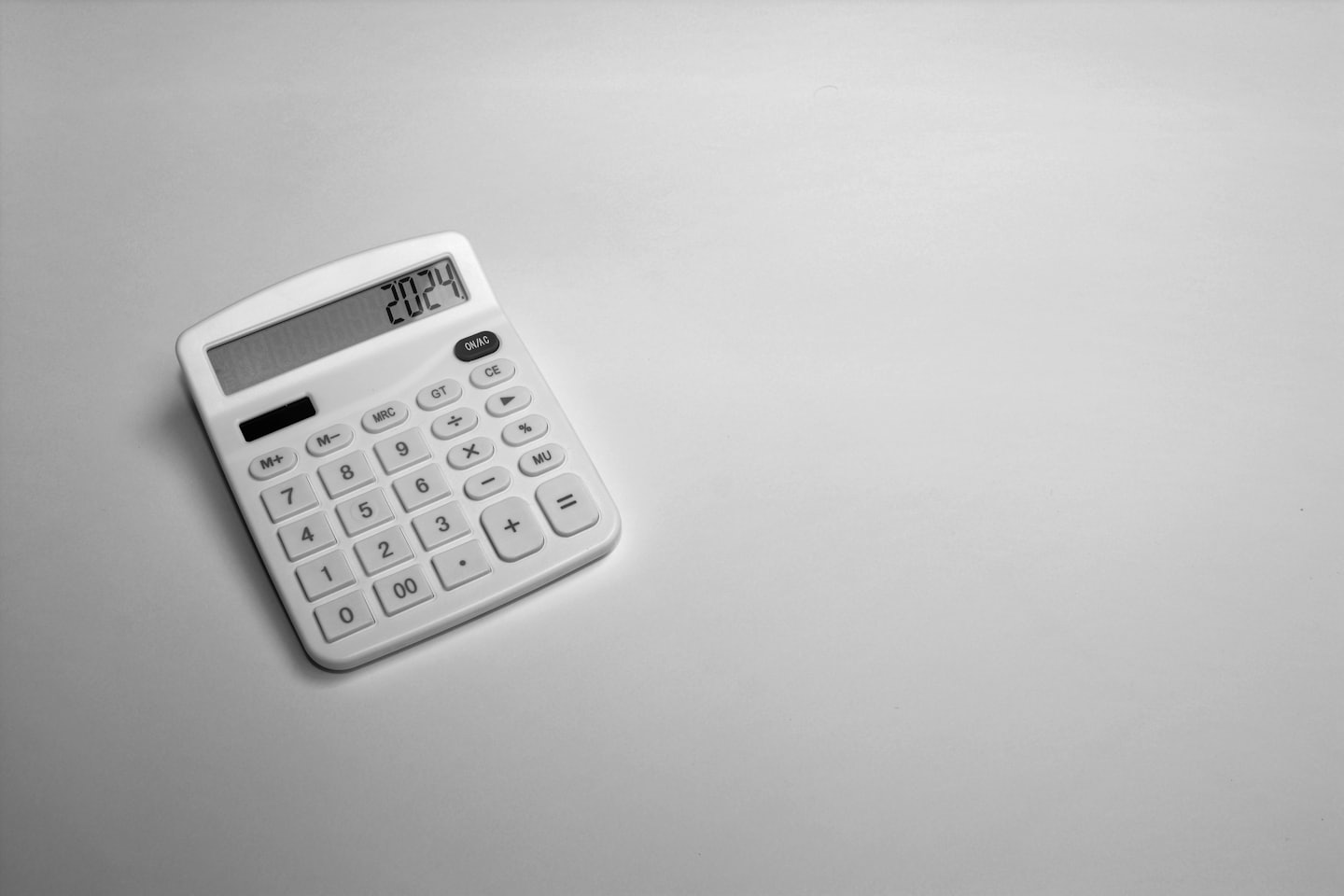White calculator on a gray surface.